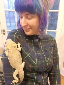 The author, Jora Anderson, with a bearded dragon on her arm